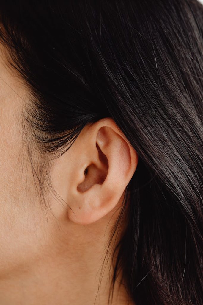 Detailed close-up image showcasing a human ear and dark hair.